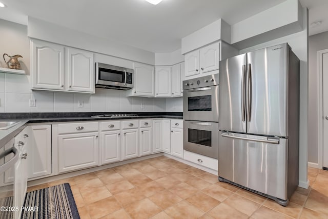 174 Lee Rd, Shohola, PA 18458 - kitchen with appliances with stainless steel finishes, dark countertops, white cabinets, and backsplash