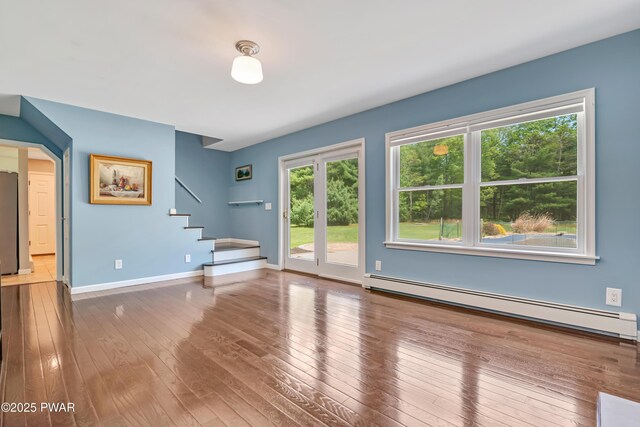 174 Lee Rd, Shohola, PA 18458 - unfurnished living room with a baseboard heating unit, stairway, hardwood / wood-style flooring, and baseboards