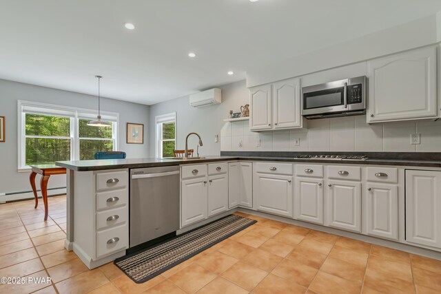174 Lee Rd, Shohola, PA 18458 - kitchen featuring appliances with stainless steel finishes, a wall unit AC, a sink, dark countertops, and recessed lighting