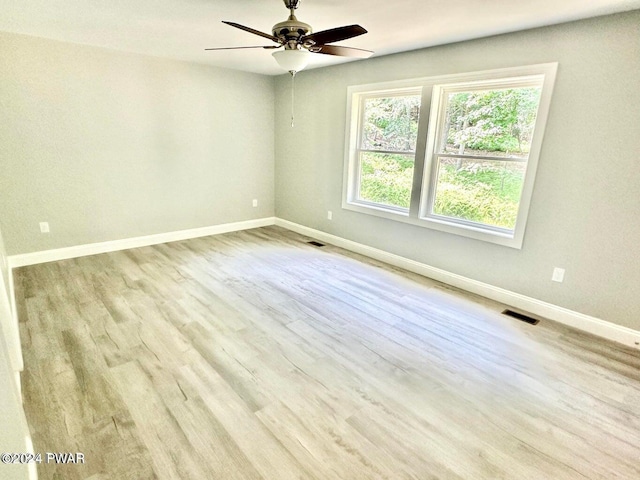 spare room with ceiling fan and light wood-type flooring