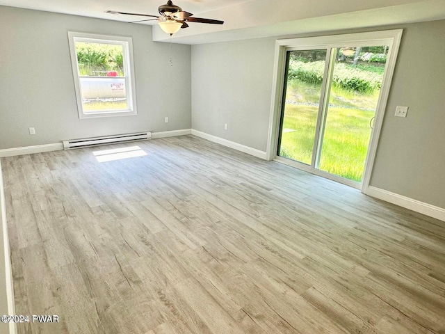 empty room featuring baseboard heating, ceiling fan, and light wood-type flooring