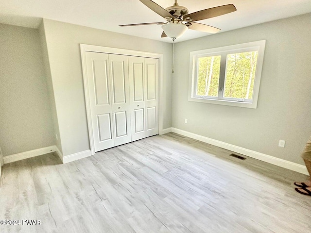 unfurnished bedroom with ceiling fan, a closet, and light hardwood / wood-style flooring