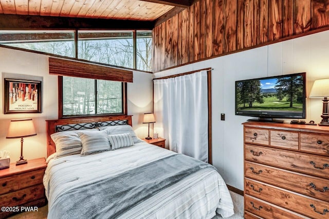 bedroom with lofted ceiling with beams, wooden walls, and wood ceiling