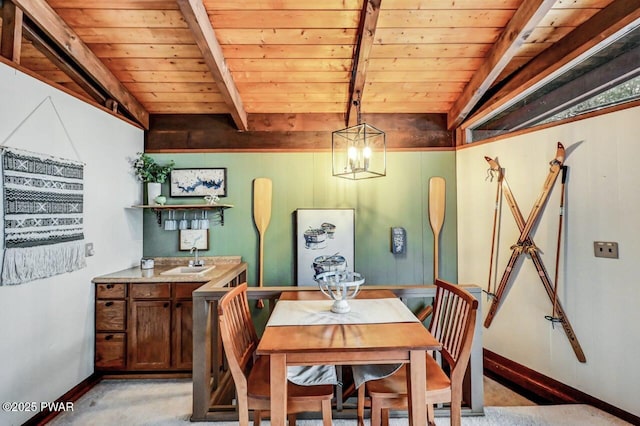 dining area with sink, wooden ceiling, and beam ceiling