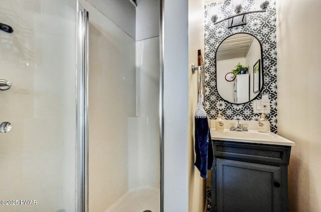 bathroom featuring a shower with door and vanity