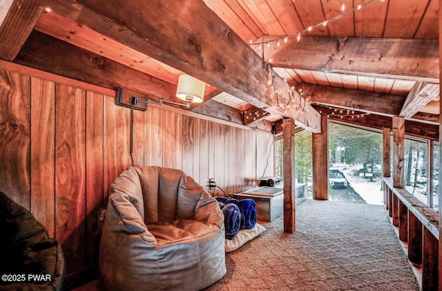 interior space with ornate columns, wood walls, carpet flooring, wood ceiling, and beam ceiling