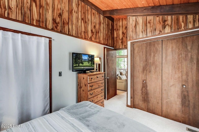 bedroom with wood ceiling, vaulted ceiling with beams, light colored carpet, a closet, and wood walls