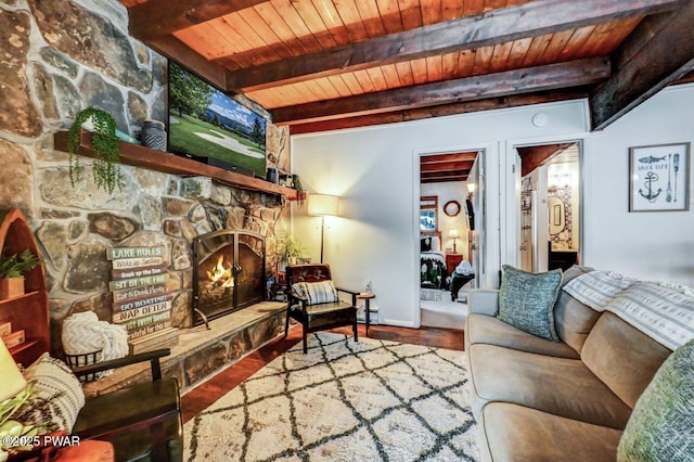 living room with wood ceiling, wood-type flooring, a stone fireplace, and beamed ceiling