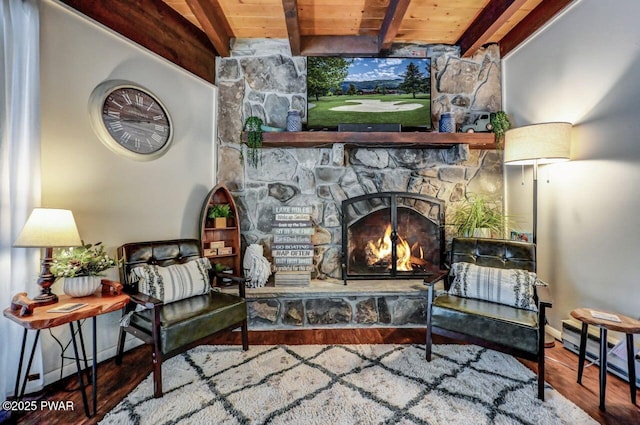 living area featuring beam ceiling, hardwood / wood-style flooring, wood ceiling, and a fireplace