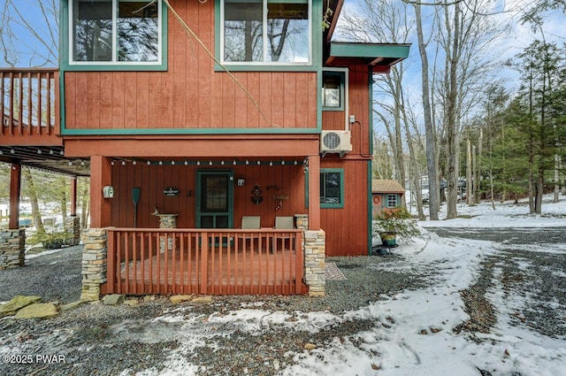 snow covered back of property with ac unit