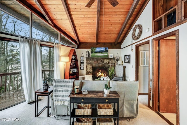 sunroom with lofted ceiling with beams, ceiling fan, wood ceiling, and a fireplace