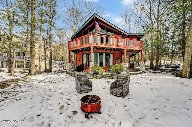 snow covered property featuring a fire pit and a deck