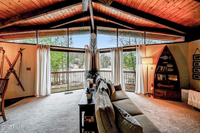 carpeted living room featuring lofted ceiling with beams, wooden ceiling, and a wall of windows