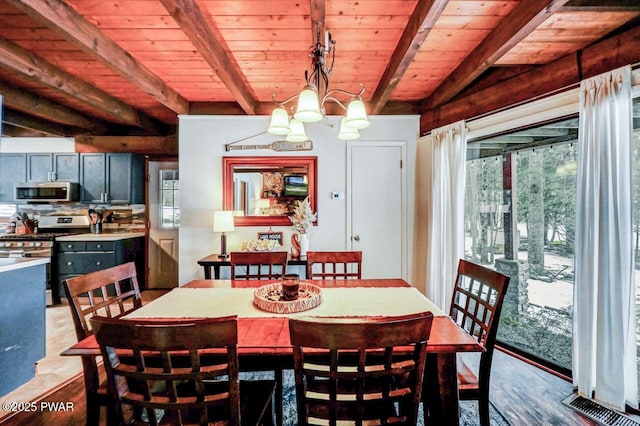 dining space with plenty of natural light, beamed ceiling, and light wood-type flooring