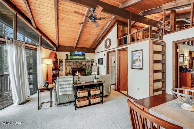 carpeted living room with ceiling fan, high vaulted ceiling, a stone fireplace, wooden ceiling, and beamed ceiling