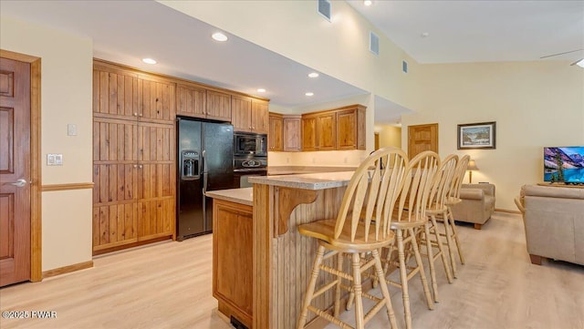 11 Coyote Rdg, Hawley, PA 18428 - kitchen featuring black appliances, light wood-style floors, a breakfast bar area, light countertops, and recessed lighting