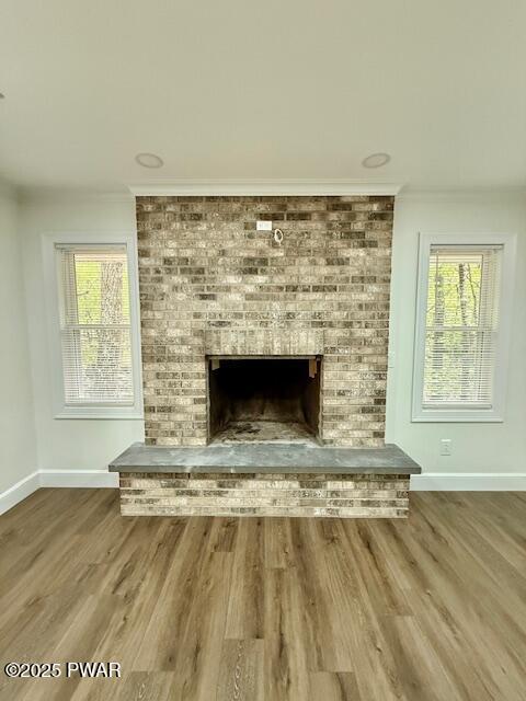404 Forest Dr, Lords Valley, PA 18428 - detailed view of baseboards, a brick fireplace, wood finished floors, and ornamental molding