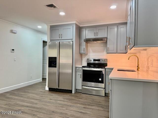 404 Forest Dr, Lords Valley, PA 18428 - kitchen featuring appliances with stainless steel finishes, gray cabinetry, a sink, crown molding, and backsplash