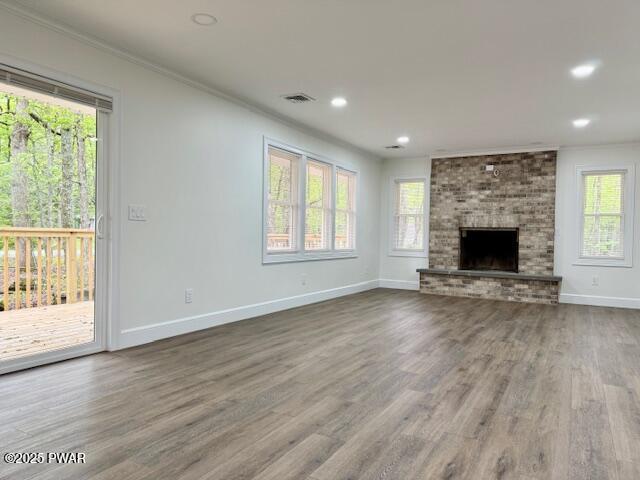 404 Forest Dr, Lords Valley, PA 18428 - unfurnished living room featuring ornamental molding, healthy amount of natural light, wood finished floors, baseboards, and recessed lighting