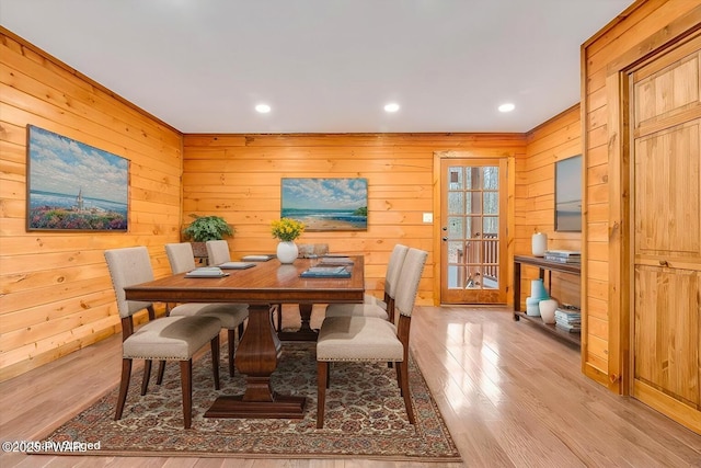 dining area featuring wooden walls and light hardwood / wood-style floors