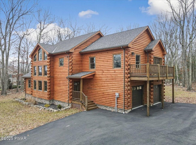 cabin featuring a deck and a garage