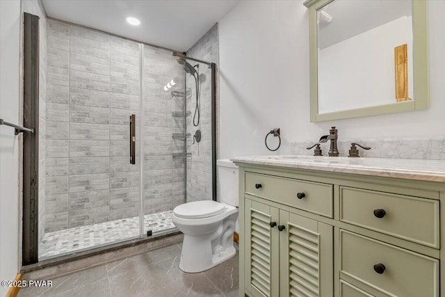 bathroom featuring vanity, toilet, and a shower with door