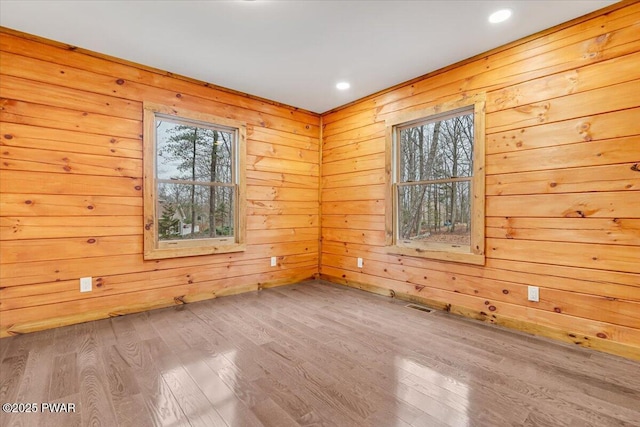 spare room with wooden walls and hardwood / wood-style floors