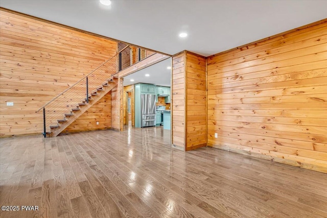 empty room with wood walls and hardwood / wood-style flooring