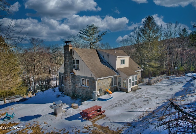 exterior space featuring stone siding and a chimney