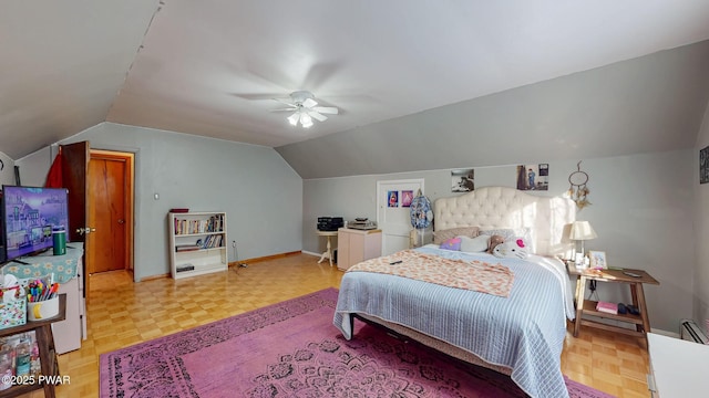 bedroom with a ceiling fan, vaulted ceiling, and baseboards