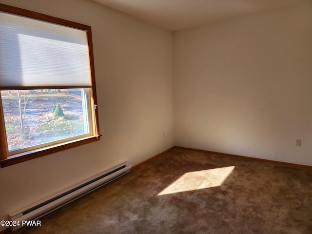 spare room featuring a baseboard heating unit and carpet flooring