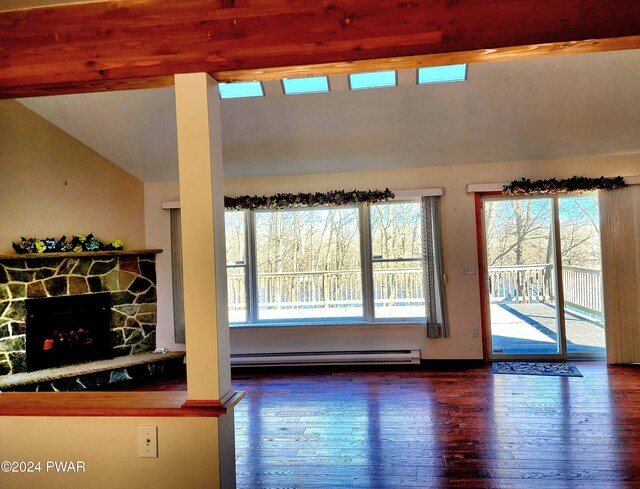 living room with baseboard heating, a stone fireplace, dark wood-type flooring, and lofted ceiling