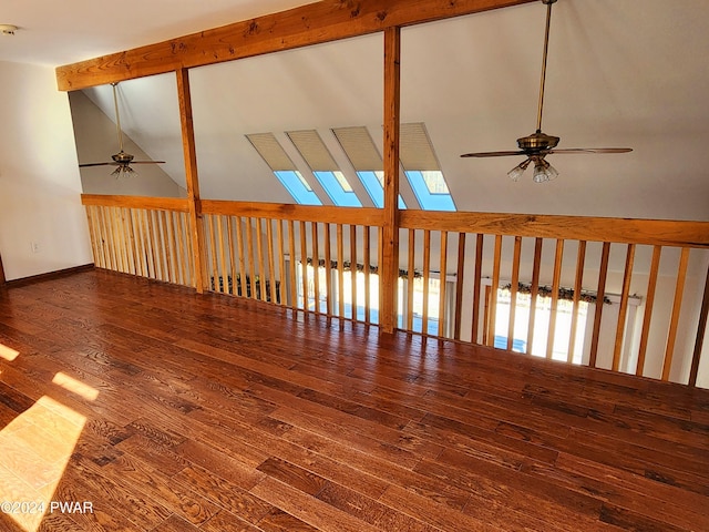 spare room with hardwood / wood-style floors, lofted ceiling with skylight, and ceiling fan