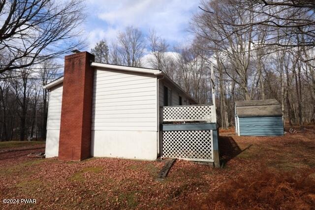 view of side of home with a shed