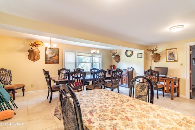 dining space with light tile patterned flooring and an inviting chandelier