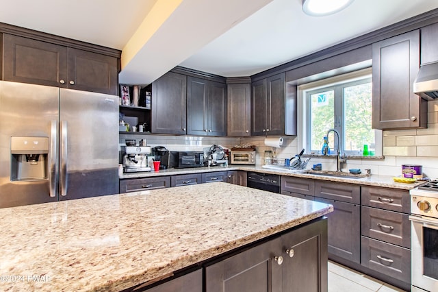 kitchen featuring dark brown cabinetry, light stone countertops, gas range gas stove, and stainless steel refrigerator with ice dispenser