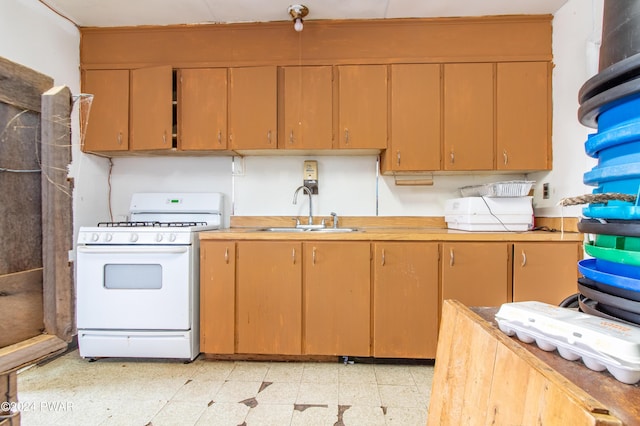 kitchen with white gas range and sink