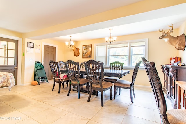 tiled dining room with an inviting chandelier