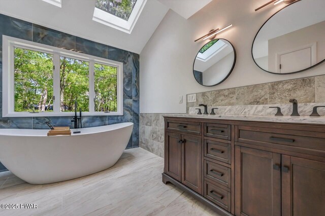 103 Goldrush Dr, Lords Valley, PA 18428 - full bath featuring tile walls, lofted ceiling, a freestanding bath, vanity, and a skylight