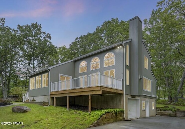 103 Goldrush Dr, Lords Valley, PA 18428 - rear view of house with a wooden deck, a chimney, a yard, an attached garage, and view of wooded area