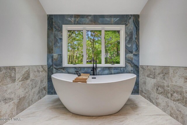 103 Goldrush Dr, Lords Valley, PA 18428 - full bathroom featuring tile walls, a soaking tub, marble tiled floors, and healthy amount of natural light