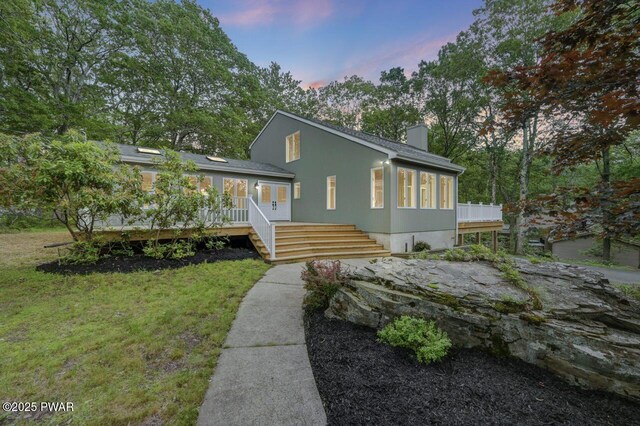 103 Goldrush Dr, Lords Valley, PA 18428 - view of front of house featuring a chimney, a wooden deck, a front lawn, and french doors