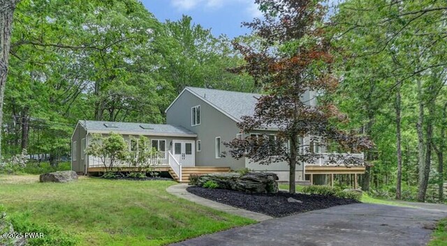 103 Goldrush Dr, Lords Valley, PA 18428 - view of front of property featuring a wooden deck, stucco siding, and a front lawn