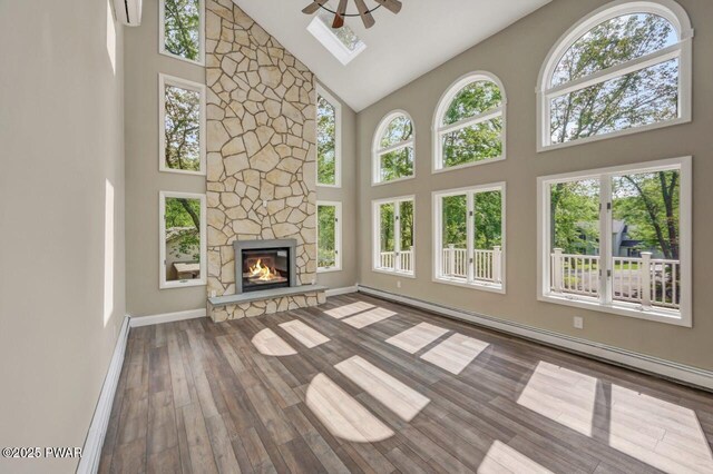 103 Goldrush Dr, Lords Valley, PA 18428 - unfurnished living room featuring high vaulted ceiling, plenty of natural light, wood finished floors, a stone fireplace, and ceiling fan