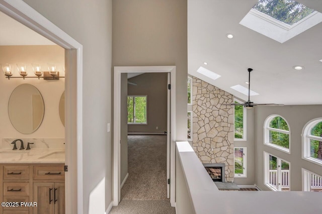103 Goldrush Dr, Lords Valley, PA 18428 - stairway featuring a skylight, carpet flooring, high vaulted ceiling, a fireplace, and recessed lighting