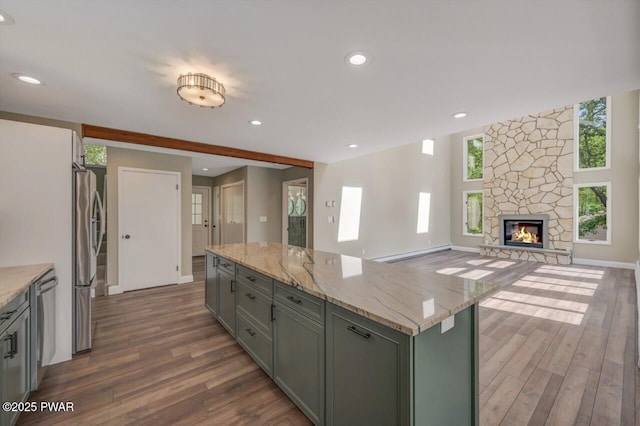 103 Goldrush Dr, Lords Valley, PA 18428 - kitchen with a baseboard heating unit, appliances with stainless steel finishes, dark wood-type flooring, a stone fireplace, and light stone countertops