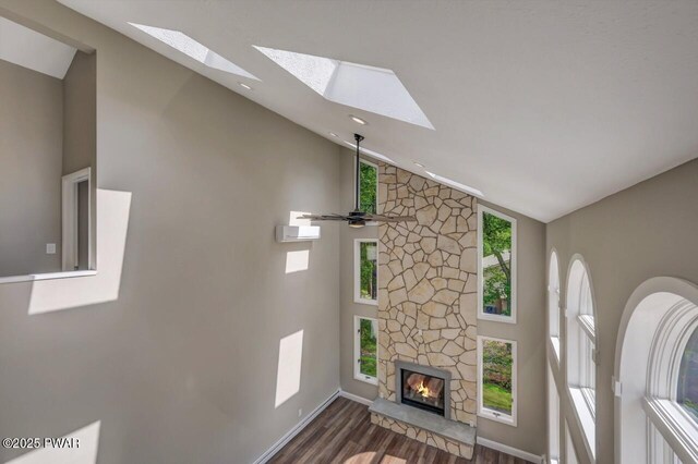103 Goldrush Dr, Lords Valley, PA 18428 - unfurnished living room with a skylight, wood finished floors, a stone fireplace, ceiling fan, and high vaulted ceiling