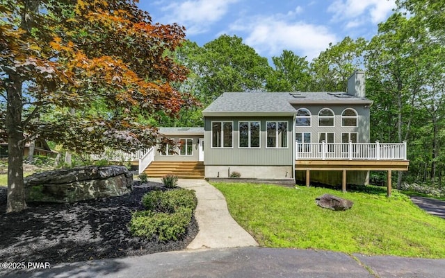 103 Goldrush Dr, Lords Valley, PA 18428 - back of property with a chimney, a wooden deck, a yard, an outdoor fire pit, and roof with shingles