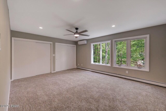 103 Goldrush Dr, Lords Valley, PA 18428 - unfurnished bedroom with a baseboard radiator, a wall mounted air conditioner, two closets, carpet flooring, and recessed lighting