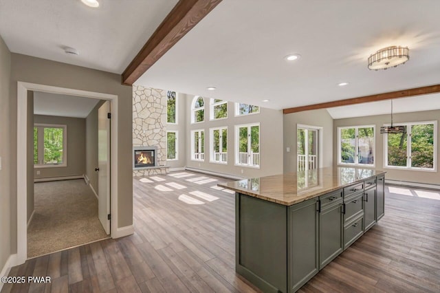 103 Goldrush Dr, Lords Valley, PA 18428 - kitchen featuring gray cabinets, beam ceiling, dark wood-style floors, light stone countertops, and a fireplace